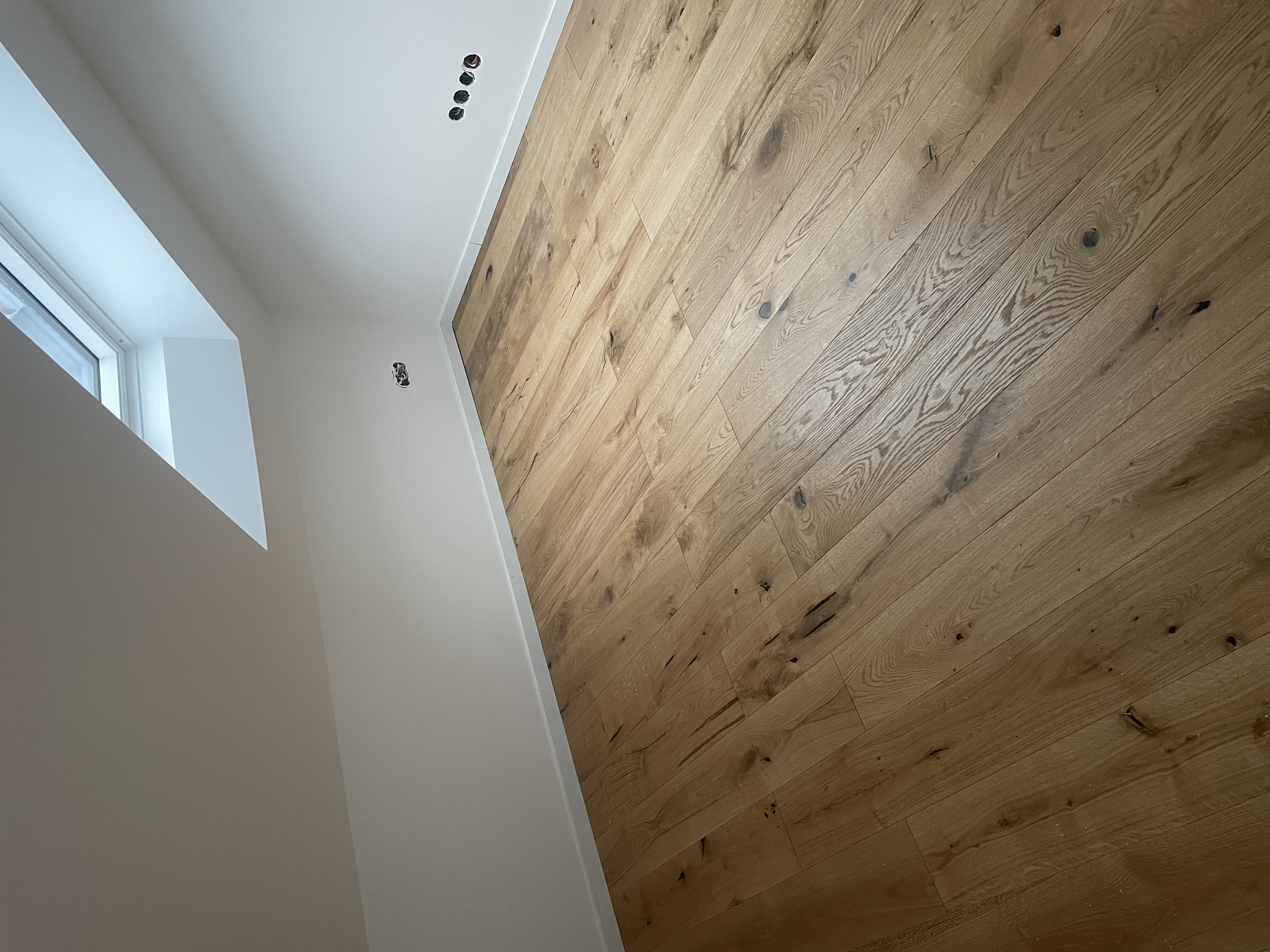 Fertiggestellter, heller Wohnraum mit Parkettboden als Referenz